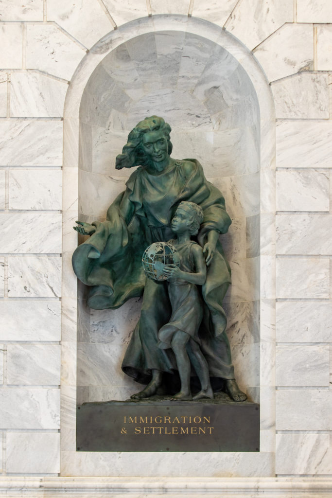 Immigration and Settlement bronze sculpture in marble niche.