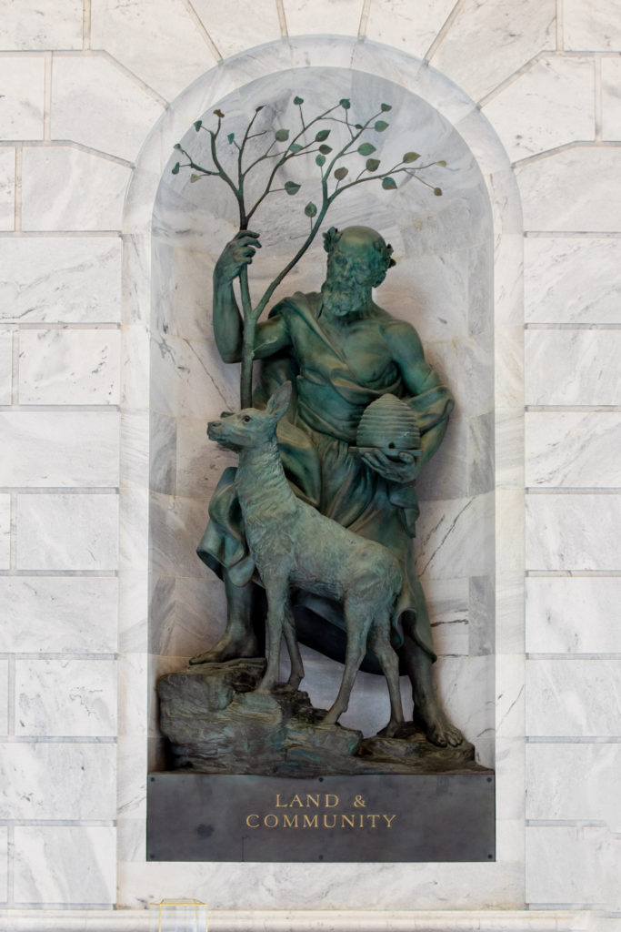 Land and Community bronze sculpture in marble niche.