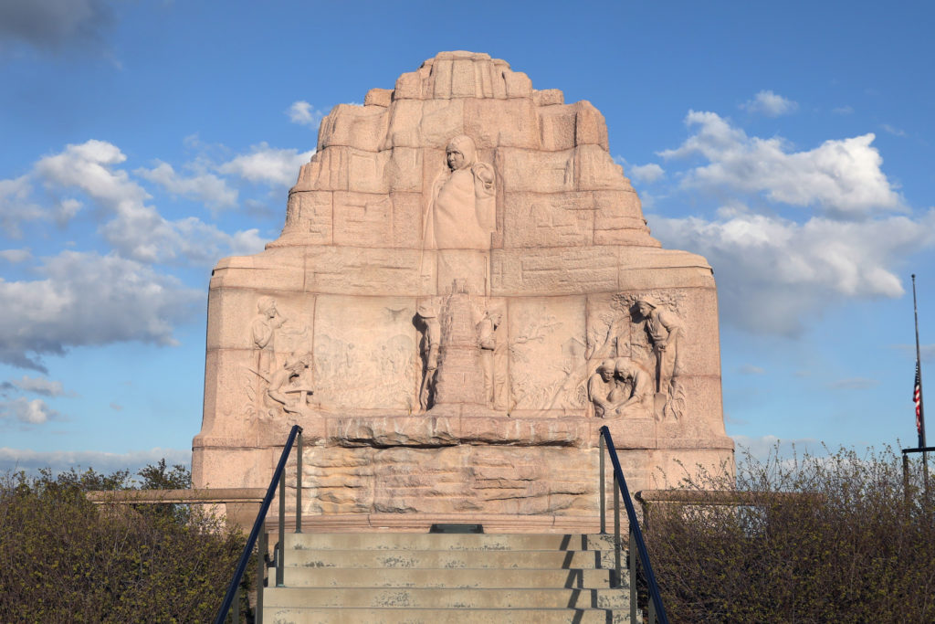Side view of the Mormon Battalion Monument featuring pink granite and bronze.