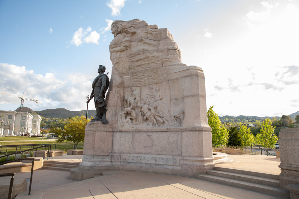 Side view of the Mormon Battalion Monument featuring pink granite and bronze.