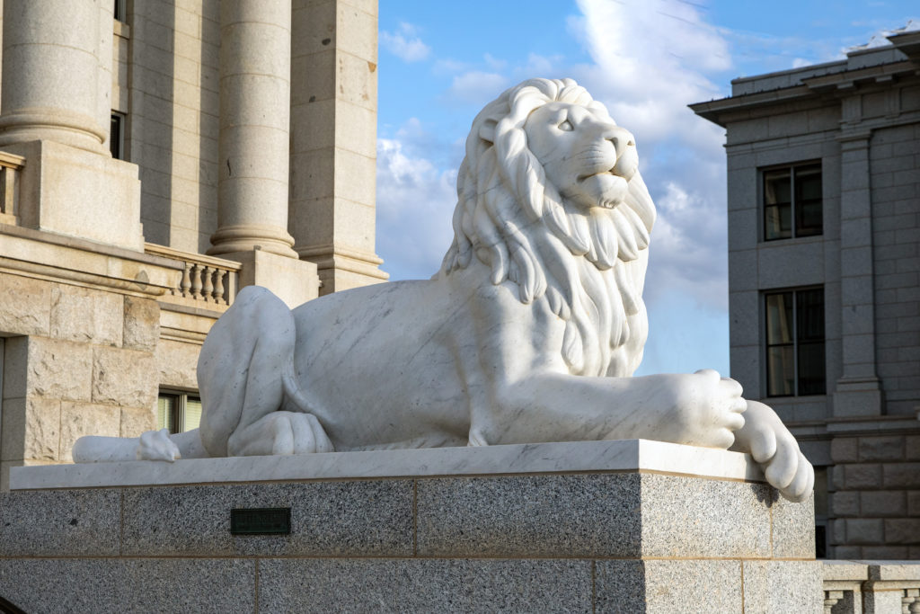 Marble sculpture of a lion laying down depicting integrity at the entry way of the Utah State Capitol.