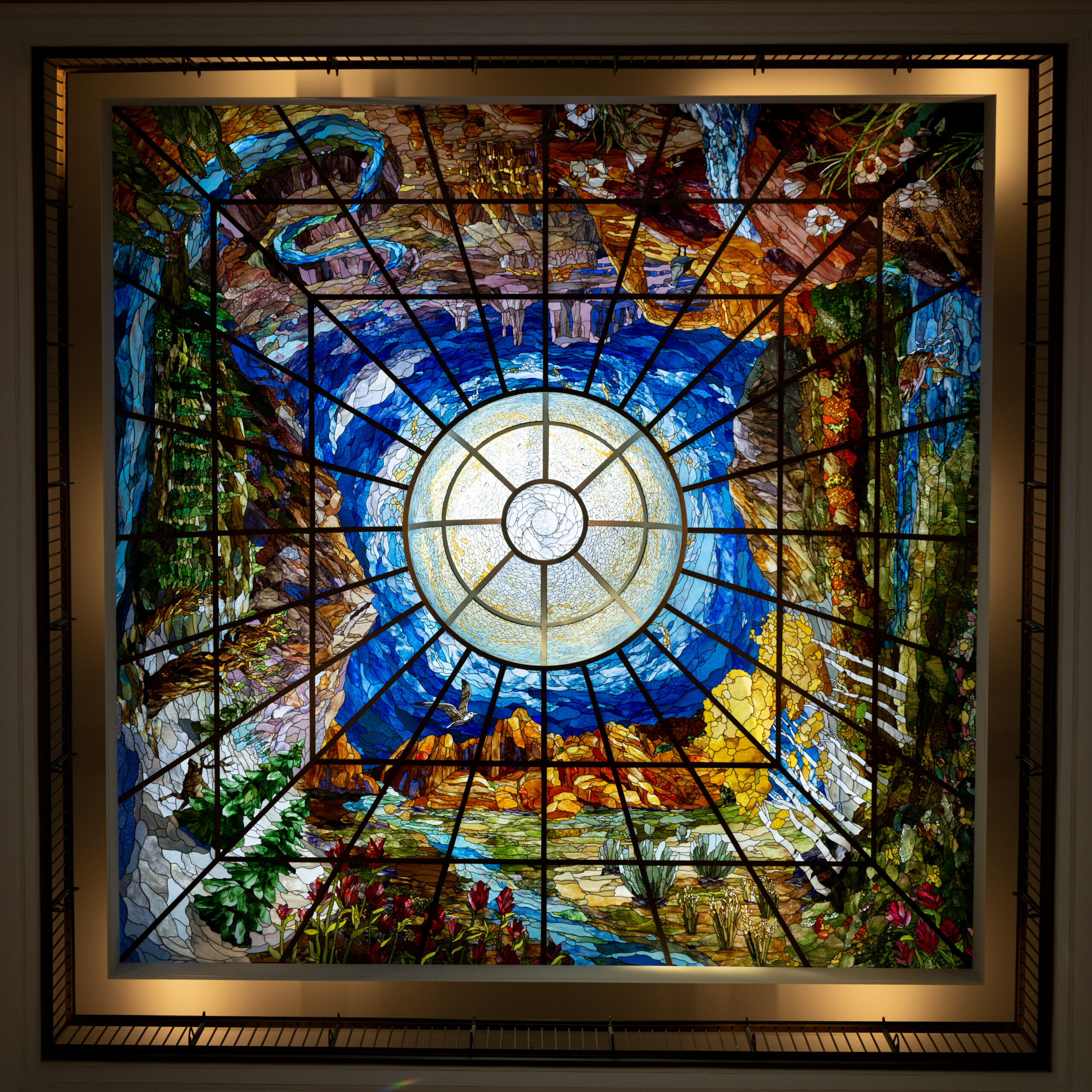 lay light or stained glass, of the North Capitol Building with different features and places of Utah such as aspen trees, Goblin Valley, Arches, rivers.