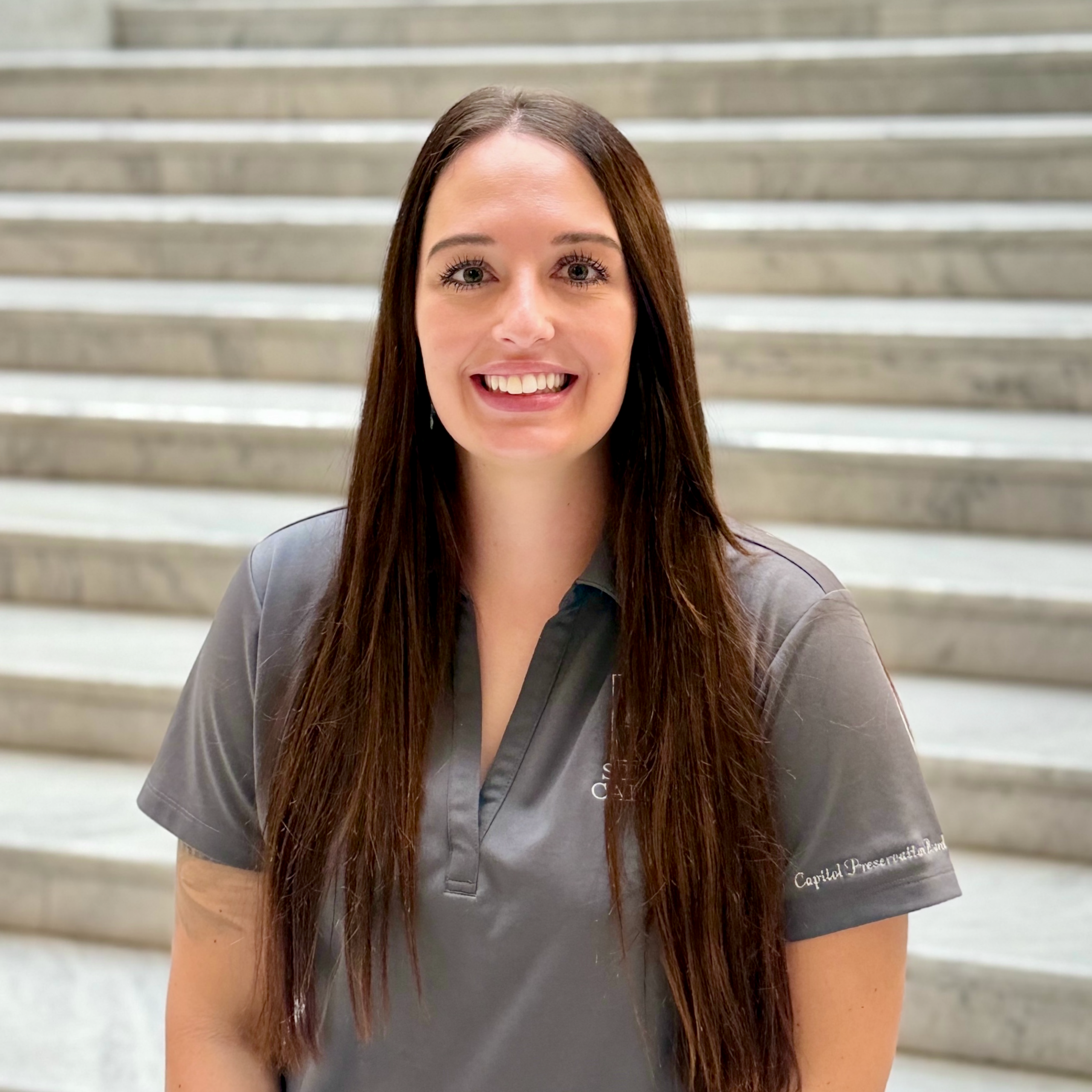 brown-haired woman with a grey polo with State of Utah logo